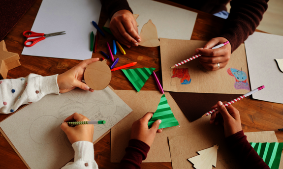 3 Personen basteln für die Weihnachtssaison an einem Tisch